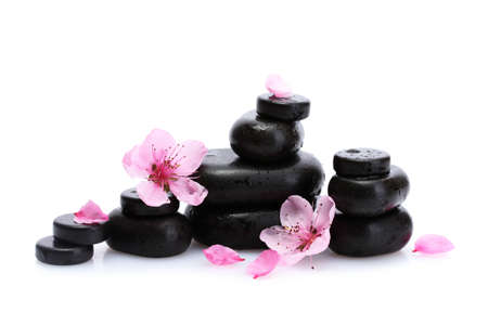 Spa stones with drops and pink sakura flowers isolated on white
の写真素材