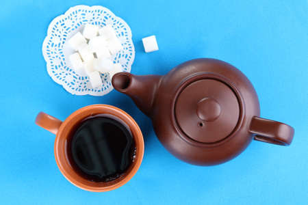 Top view of cup of tea and teapot on blue tableclothsの写真素材