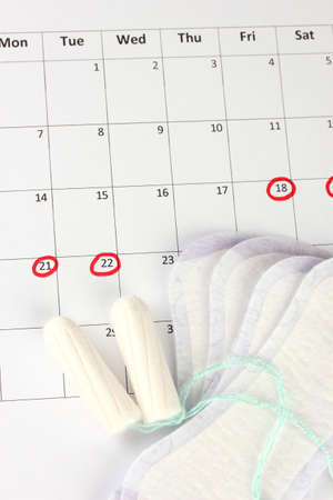menstruation calendar with sanitary pads and tampons, close-upの写真素材