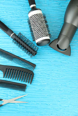 Comb brushes, hairdryer and cutting shears,on color backgroundの写真素材