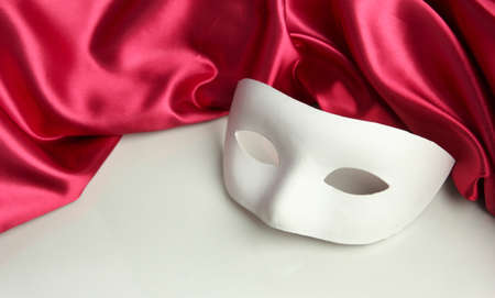 White mask and red silk fabric, isolated on whiteの写真素材