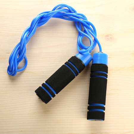 Blue skipping rope, on wooden backgroundの写真素材