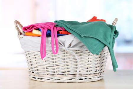 Clothes in wooden basket on table in roomの写真素材