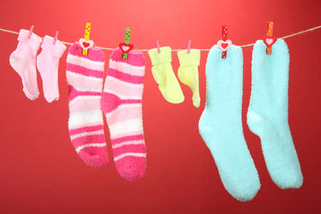Colorful socks hanging on clothesline, on color backgroundの写真素材