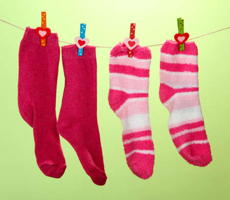 Colorful socks hanging on clothesline, on color backgroundの写真素材