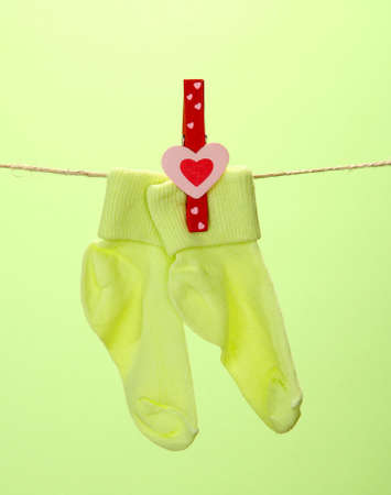Colorful socks hanging on clothesline, on color backgroundの写真素材