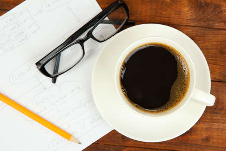 Cup of coffee on worktable covered with documents close upの写真素材