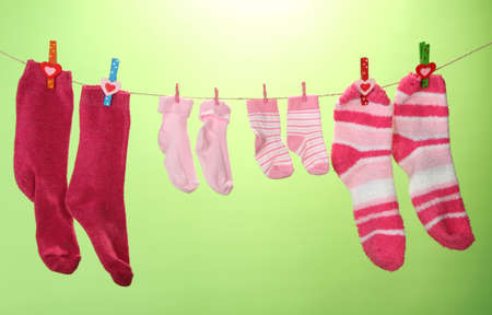 Colorful socks hanging on clothesline, on color backgroundの写真素材