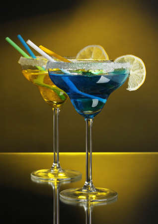 Yellow and blue cocktails in glasses on color backgroundの写真素材