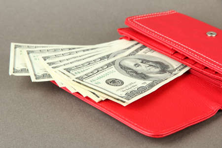 Purse with hundred dollar banknotes, on color backgroundの写真素材