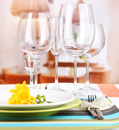 Table setting with glasses for different drinks on table on room backgroundの写真素材