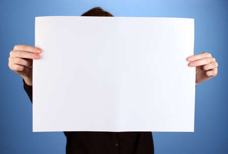 Woman holding blank sign in front her face, on color backgroundの写真素材