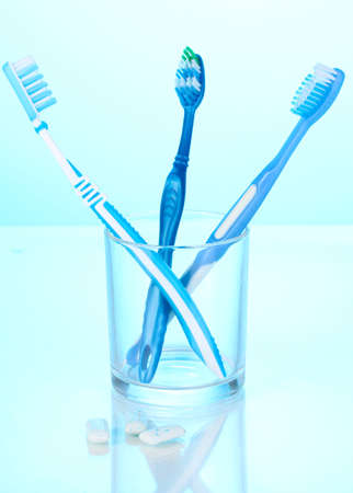 Toothbrush in glass and chewing gum on blue backgroundの写真素材