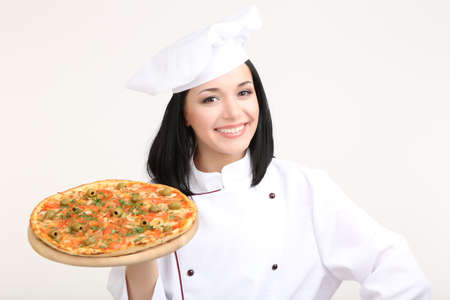 Beautiful girl chief-cooker with pizza isolated on whiteの写真素材