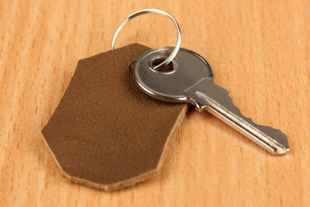 Key with leather trinket on wooden backgroundの写真素材