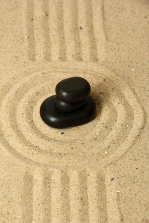 Zen garden with raked sand and round stones close upの写真素材