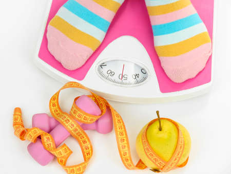 Female feet on scales, isolated on whiteの写真素材