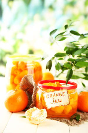Orange jam with zest and tangerines, on white wooden tableの写真素材