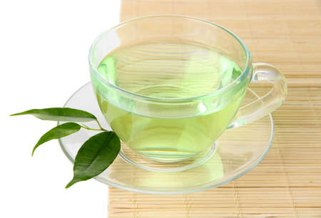 Transparent cup of green tea on bamboo mat, isolated on whiteの写真素材