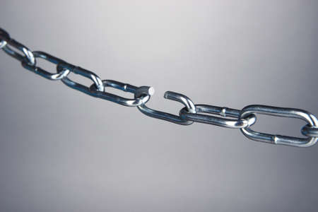 Broken chain on gray backgroundの写真素材
