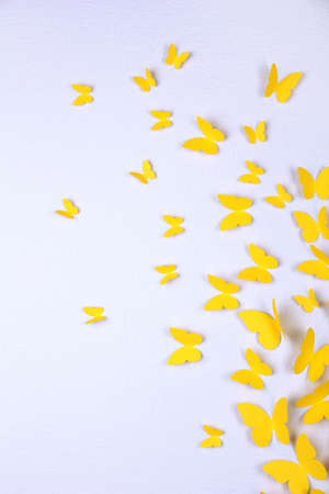 Paper yellow butterflies fly on wall in different directionsの写真素材