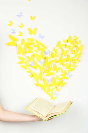 Paper yellow butterfly in form of heart fly out bookの写真素材