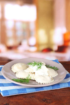 Tasty dumplings on plate, on wooden tableの写真素材