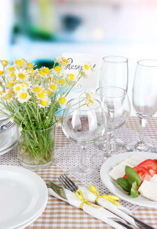 Table setting with chamomiles on checkered tablecloth on window backgroundの写真素材