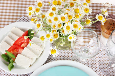 Table setting with chamomiles on checkered tableclothの写真素材