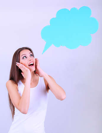 Young pretty woman with empty think bubble on grey backgroundの写真素材