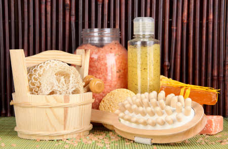 Cleanser, brush and cosmetics for shower on table on bamboo backgroundの写真素材