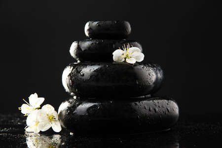 Spa stones and white flowers isolated on blackの写真素材