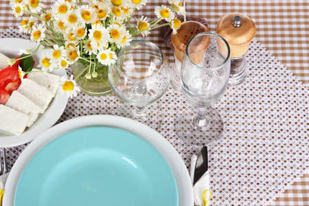 Table setting with chamomiles on checkered tableclothの写真素材