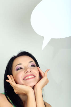 Thought girl in bubble next to it on grey backgroundの写真素材
