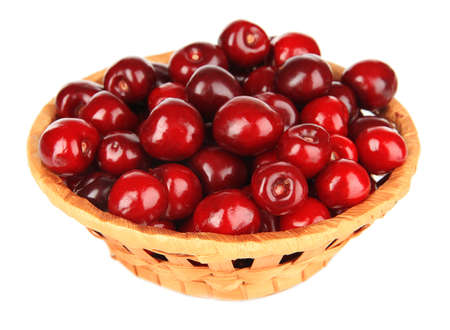 Cherry berries in wicker basket isolated on whiteの写真素材