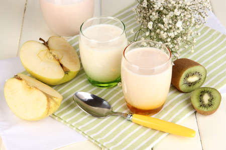 Delicious yogurts with fruits in glasses on wooden table close-upの写真素材