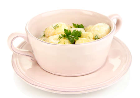 Tender young potatoes with sour cream and herbs in pan isolated on whiteの写真素材