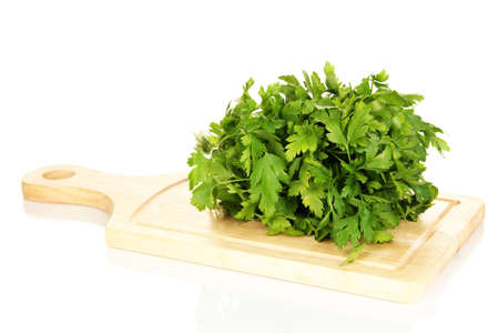 Useful parsley on wooden board isolated on whiteの写真素材