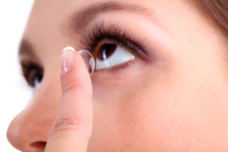 Young woman putting contact lens in her eye close upの写真素材