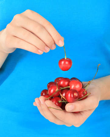 Cherry berries in hands close upの写真素材