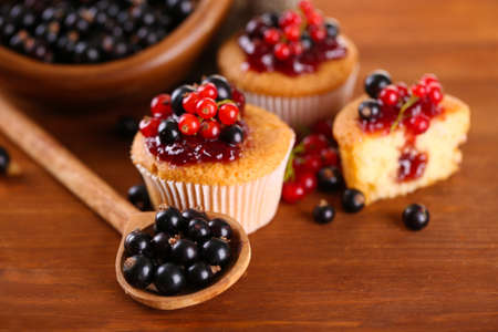Tasty muffins with berries on wooden tableの写真素材