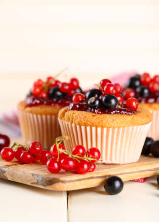 Tasty muffins with berries on white wooden tableの写真素材