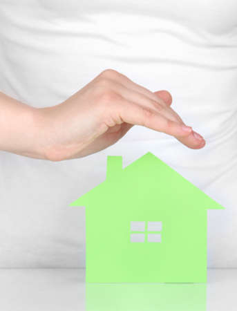 Paper house in hand isolated on whiteの写真素材