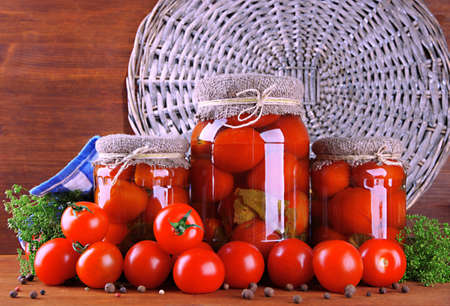 Tasty canned and fresh tomatoes on wooden tableの写真素材