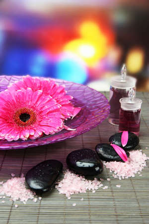 Gerbera flowers on water and spa stones on bamboo matの写真素材