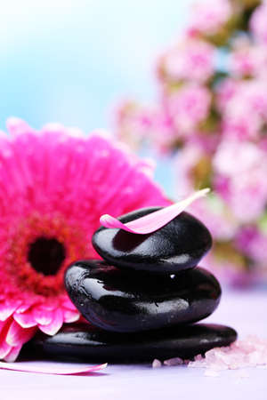 Spa stones and beautiful gerbera on wooden tableの写真素材