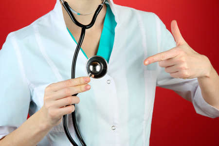 Medical doctor with stethoscope, on color backgroundの写真素材