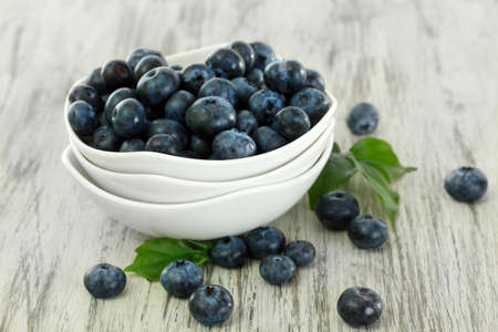 Blueberries in bowls on wooden tableの写真素材
