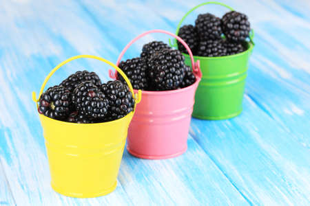 Sweet blackberries in buckets on table close-upの写真素材