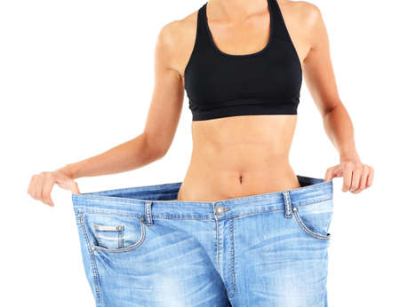 Slim girl in big jeans isolated on whiteの写真素材